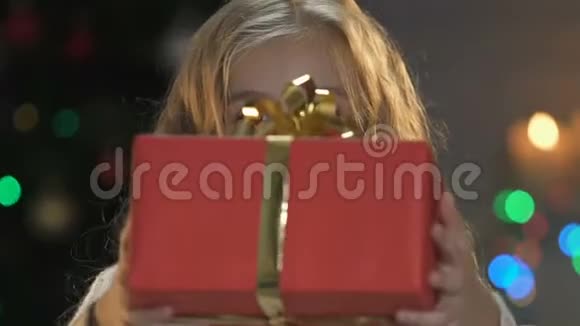 可爱的女孩展示大红盒子与蝴蝶结相机赠送圣诞礼物视频的预览图