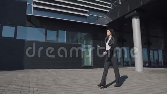 穿着商务服的年轻女性在现代建筑的背景下视频的预览图