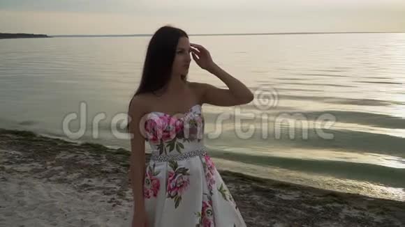 在河的背景上穿着漂亮裙子的浪漫女孩视频的预览图