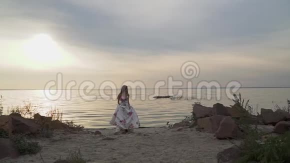 可爱的女孩穿着别致的裙子在美丽的海滩上视频的预览图