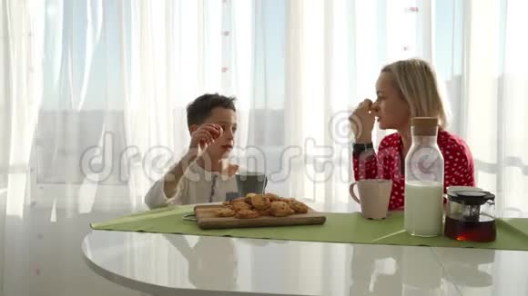 一个可爱可爱的白种人男孩正在他金发的年轻母亲旁边吃饼干弟弟在偷东西视频的预览图