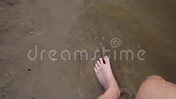 男人脚赤脚走在岸边向不同的方向溅起水滴慢动作特写镜头视频的预览图