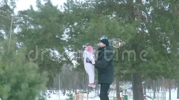 爸爸把女儿扔到冬天森林里的天空慢动作视频的预览图