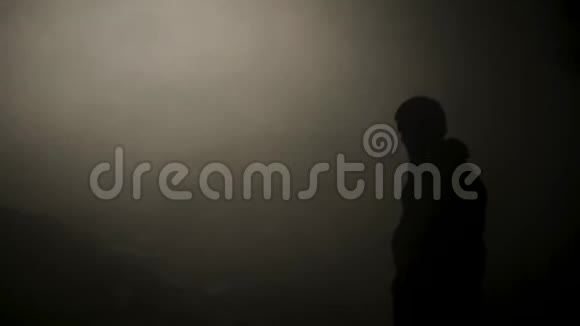 烟雾洞中人的黑色轮廓库存录像微弱的光线穿过浓雾照亮了细节视频的预览图