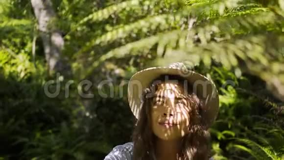 肖像女孩在阳光明媚的热带雨林中行走视频的预览图