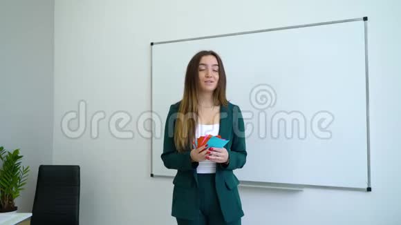 青年快乐教师在白板旁教授学生在教室里讲解任务卡视频的预览图
