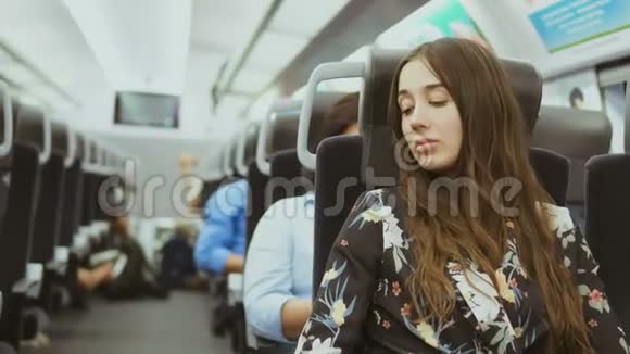 美丽的女人经过长途旅行后在公共汽车上骑累了试图在路上睡觉视频的预览图
