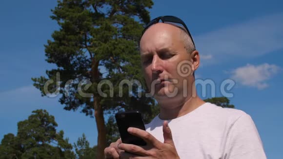 白种人在夏林绿松背景下浏览手机视频的预览图
