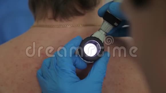 一位男性医生用电子医疗设备检查病人皮肤医疗技术特写视频的预览图