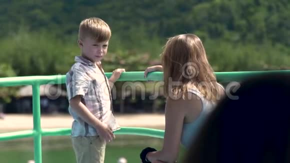 快乐男孩和妈妈在海上游轮上聊天小妈妈和小儿子在船上航行视频的预览图