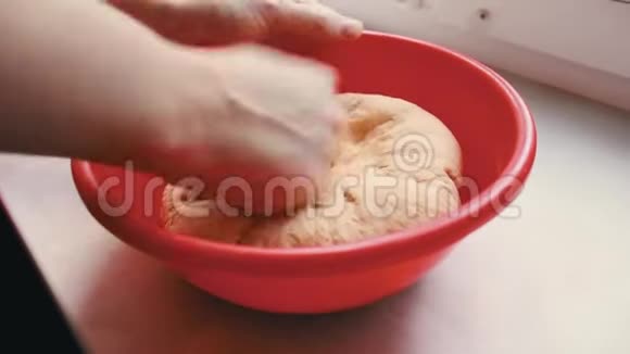 女人用手揉面面团在红碗里烤披萨视频的预览图