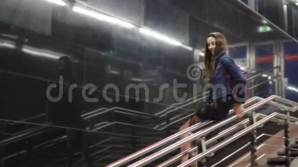 美女欢快地滑过栏杆地铁与背景黑石视频的预览图