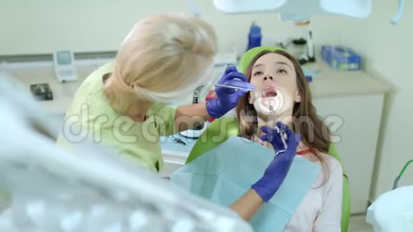 女性牙医使用口腔镜和药物注射器医生治疗病人视频的预览图