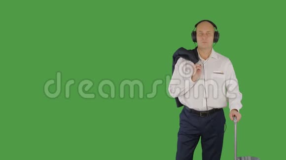 快乐的白种人商人跳舞而他听音乐在他的智能手机阿尔法频道按键绿色屏幕视频的预览图