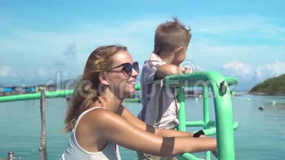 快乐的妈妈和小儿子在海上游轮上航行年轻的母亲和儿子一起乘船航行视频的预览图