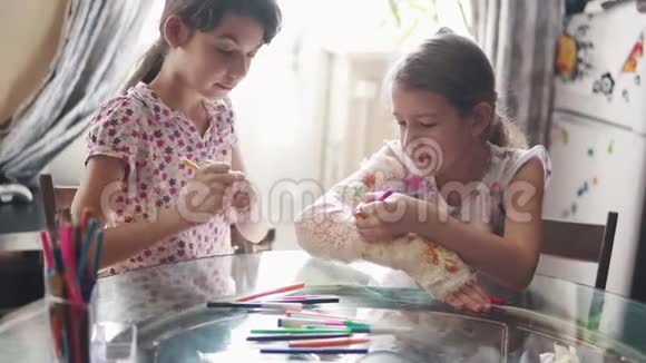 孩子们用绷带把一只涂满石膏的手臂画在一起家庭护理的概念姐姐鼓励和关心一个视频的预览图