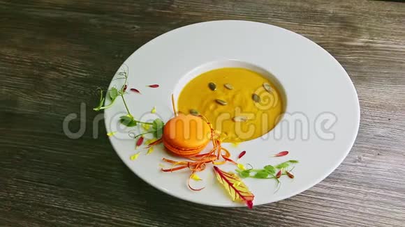在深白色的碗上观看带有橙色通心粉的南瓜奶油汤视频的预览图