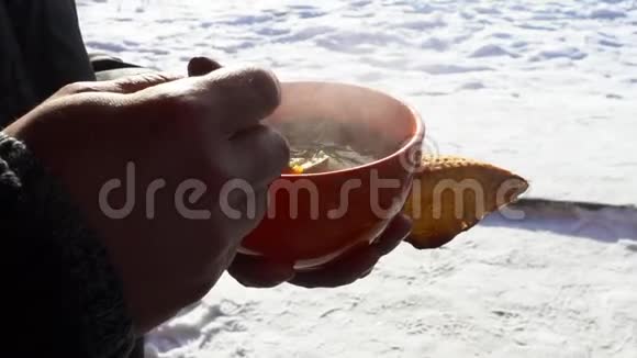 一个人在寒冷美丽的阳光下吃汤天气冷蒸汽来了视频的预览图