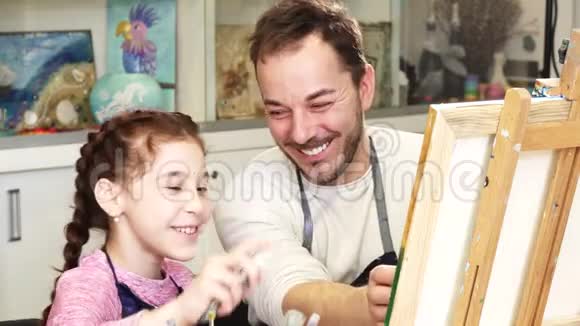 快乐的小女孩和她父亲一起画一幅画视频的预览图