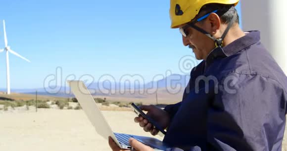 男性工程师在笔记本电脑工作时使用手机视频的预览图