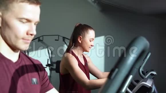 年轻夫妇在健身房的有氧运动中交谈和微笑视频的预览图