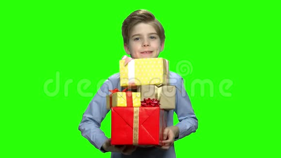 小男孩两臂抱着许多礼盒的肖像视频的预览图