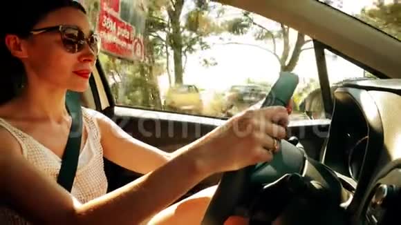 在阳光明媚的夏日戴着墨镜的美女开车视频的预览图