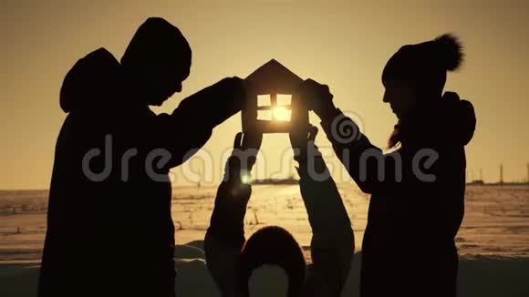 一家人在日落时分抱着纸房梦见自己的家日落时分手中的纸房剪影视频的预览图