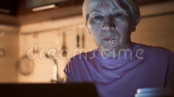 睡眼的高级女商人在家庭办公室用笔记本电脑疲惫的女性喝着纸杯里的咖啡视频的预览图