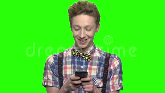 穿着时髦衣服的少年用手机发短信视频的预览图