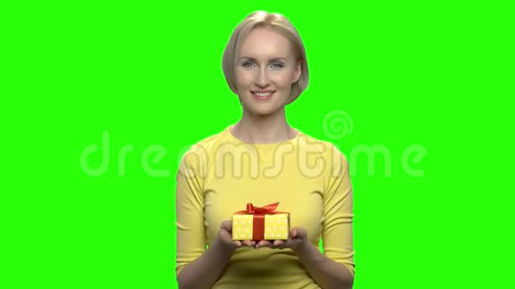 美丽成熟的女人双手拿着黄色的礼盒视频的预览图