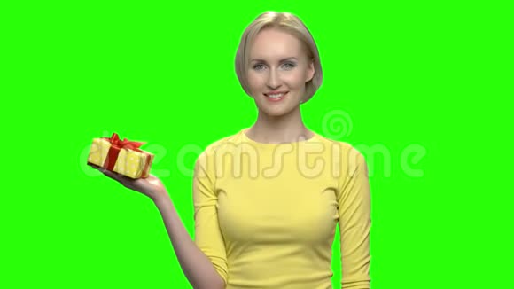 成熟的女人用一只手拿着黄色的礼盒视频的预览图