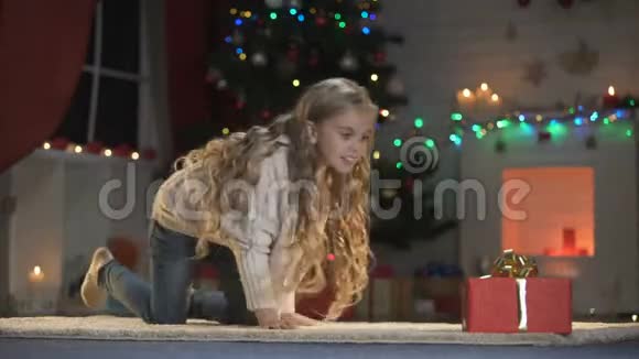 可爱的女孩爬行到期待已久的圣诞礼物圣诞老人的礼物魔术前夜视频的预览图