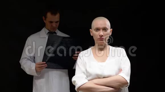 概念肿瘤患者秃头妇女和医生男子正在观看黑色背景的断层扫描结果视频的预览图