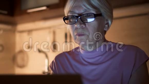 高级妇女晚上在家庭办公室用笔记本电脑工作女商人摘下眼镜揉眼睛视频的预览图