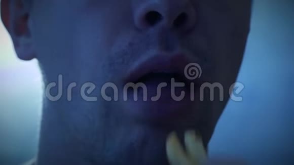 吃炸薯条的男人舔他的手指视频的预览图