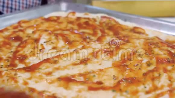 男人用酱汁涂抹比萨饼面团用磨碎的奶酪撒上双手特写做自制披萨视频的预览图