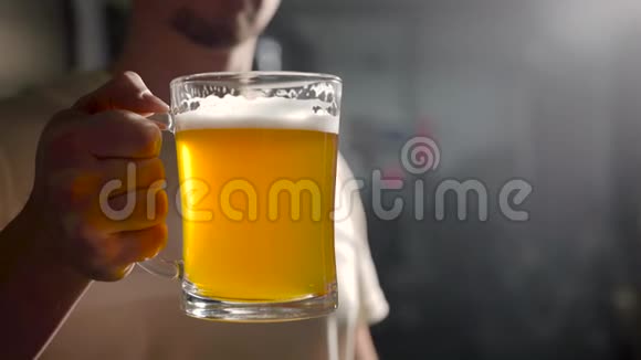 成年男子拿着装满啤酒的杯子在黑暗的房间里然后放下它酒吧老板正在赠送新啤酒视频的预览图