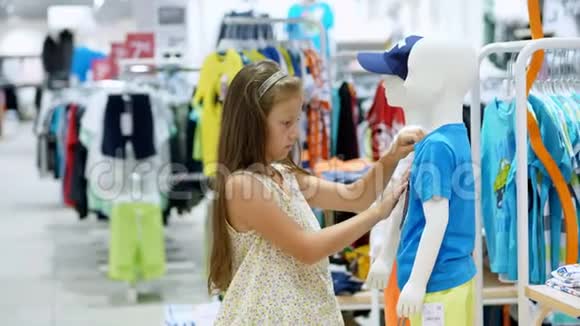 在商店里购物儿童服装部女孩孩子选择商店里的东西时尚小女孩视频的预览图