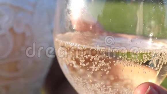 把起泡的葡萄酒从瓶子里倒入透明的玻璃杯里手里拿着一杯香槟女孩手里拿着火花和泡沫视频的预览图