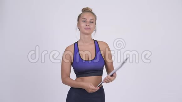 年轻漂亮的金发女郎带剪贴板的健身教练视频的预览图