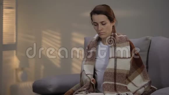 孤独抑郁的女性坐在沙发上铺着格子呢失业视频的预览图