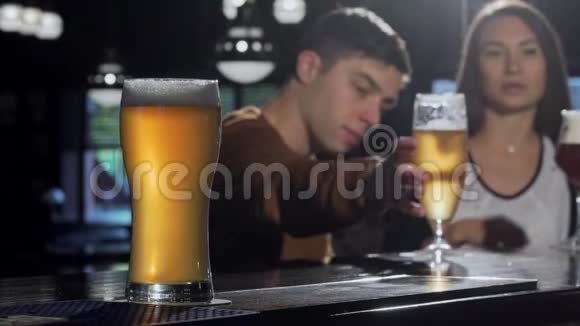 前景上的一杯美味的啤酒酒吧后面的几杯啤酒视频的预览图