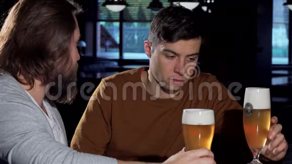 沮丧的年轻人和他的朋友在酒吧喝酒视频的预览图