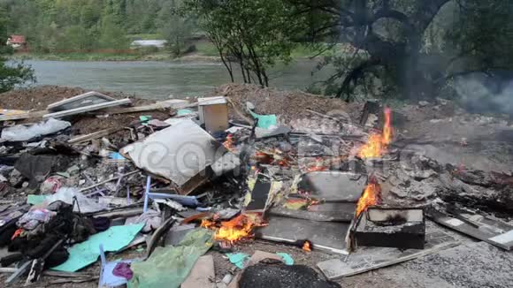 焚烧野生垃圾场河边的塑料袋瓶子垃圾和垃圾严重污染的河岸环境政策视频的预览图