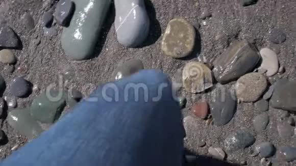 穿着蓝色牛仔裤和皮鞋走在石头上视频的预览图