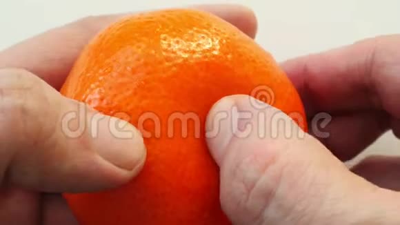双手合拢将橘子从果皮中清理出来视频的预览图