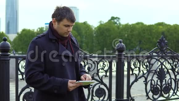 一个人在城市公园里使用平板电脑视频的预览图