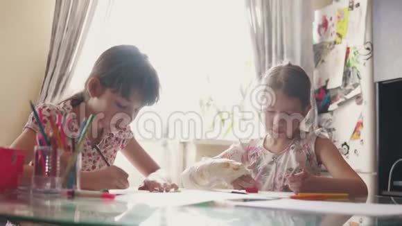 带着绷带的断臂的孩子用铅笔画画2两个小女生坐在桌边画画视频的预览图