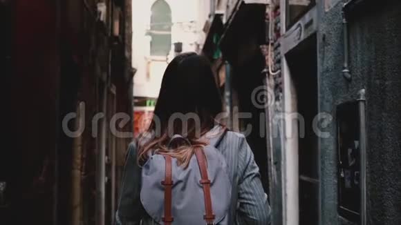 后景女商人带着背包穿着时髦的西装在威尼斯的黑暗街道上行走意大利慢动作视频的预览图